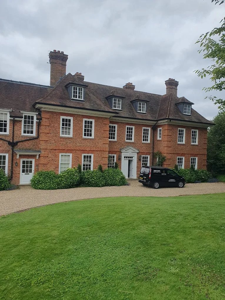 The Naish & Sons van outside a large period house with tall brick chimneys